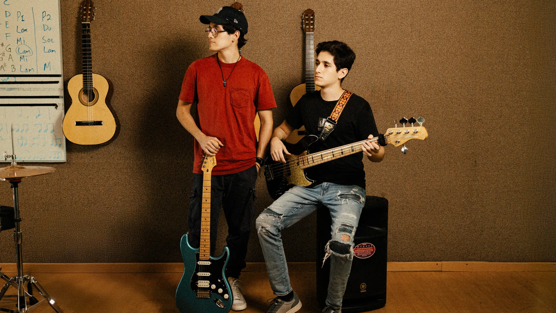 Hermanos posan con guitarra y bajo en espacio musical del Tec de Monterrey
