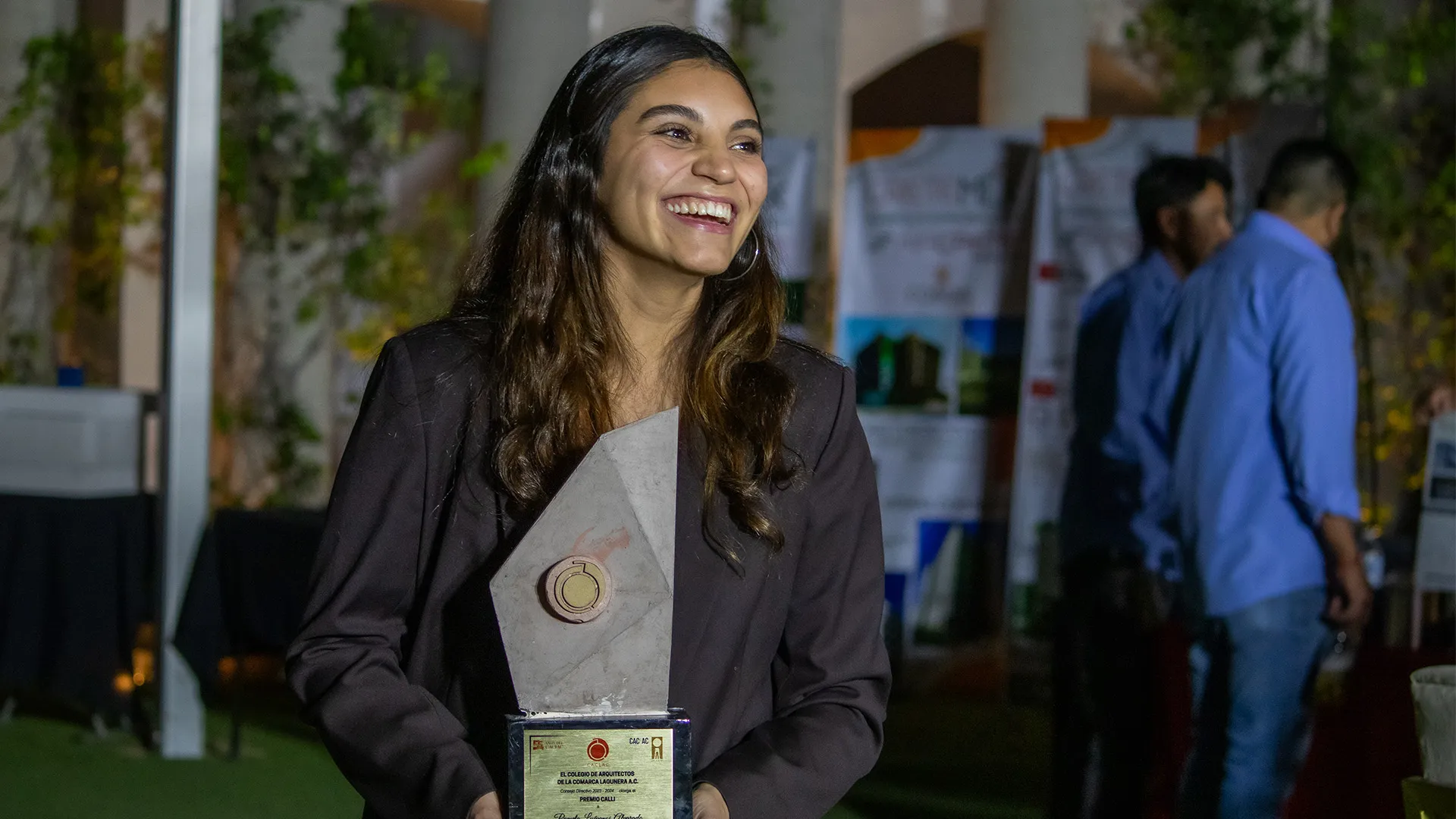 Egresada de Arquitectura del Tec de Monterrey campus Laguna sonríe al recibir premio Calli del Colegio de Arquitectos de la región
