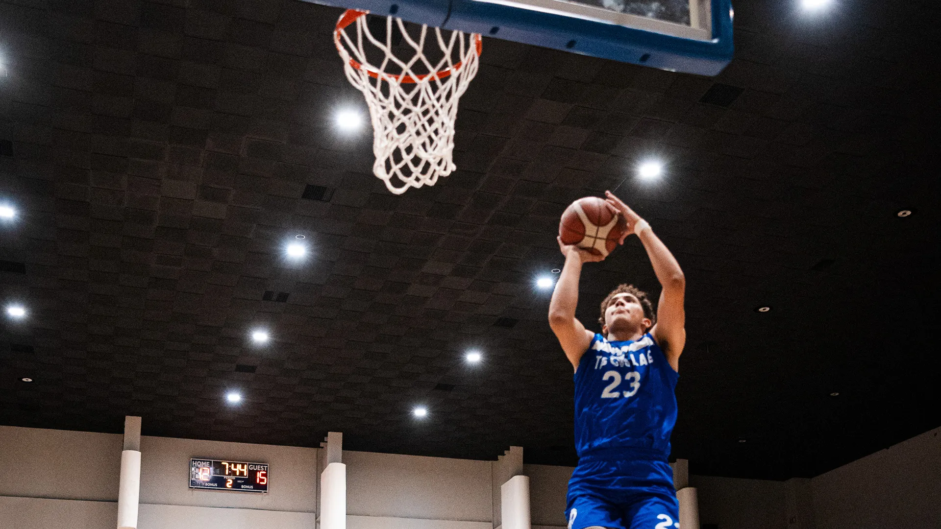 Jugador de Borregos Laguna salta y lanza balón de básquetbol para encestar