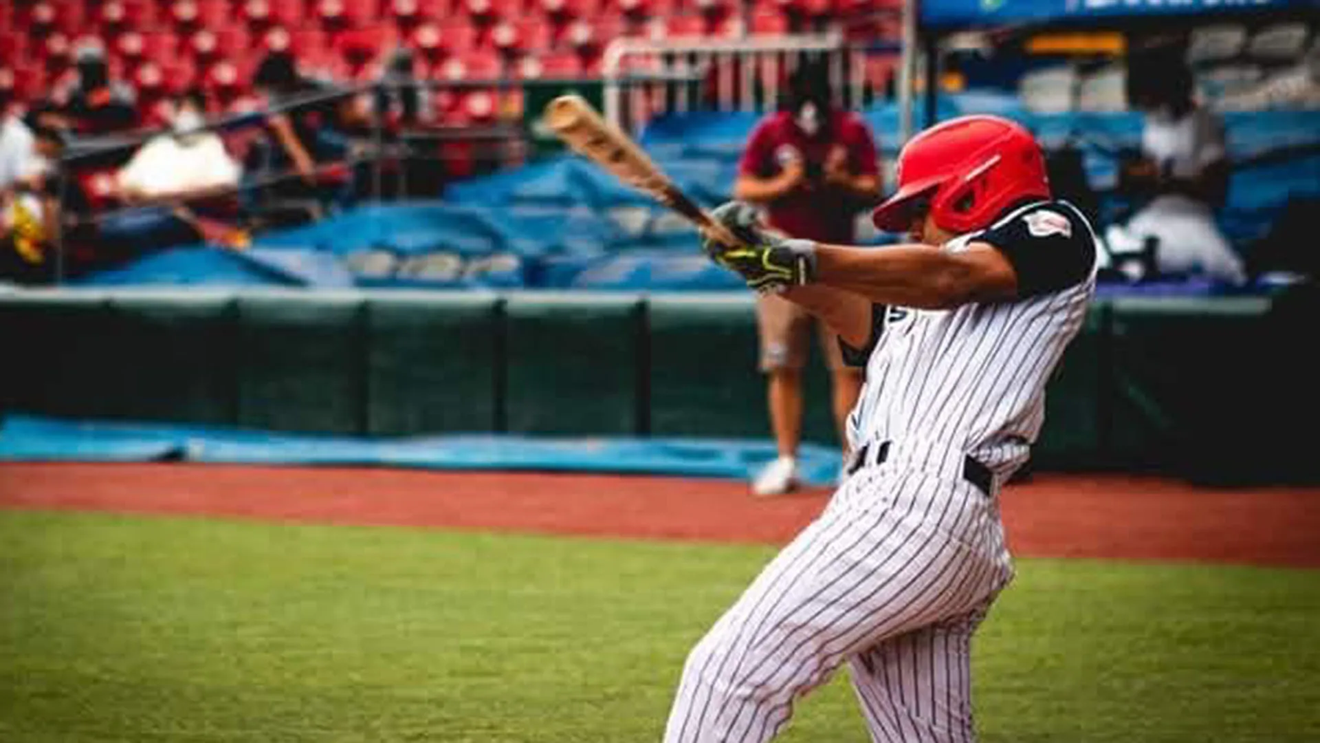 Estudiante bateando durante juego de liga de prospectos