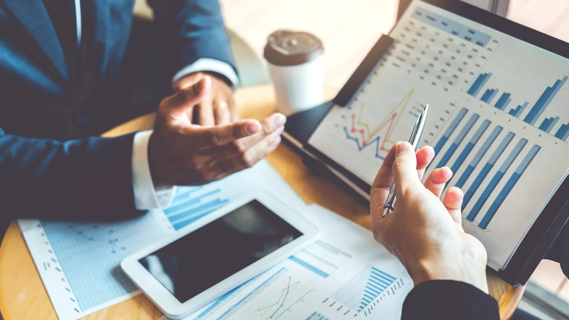 Personas analizando gráficos y datos financieros