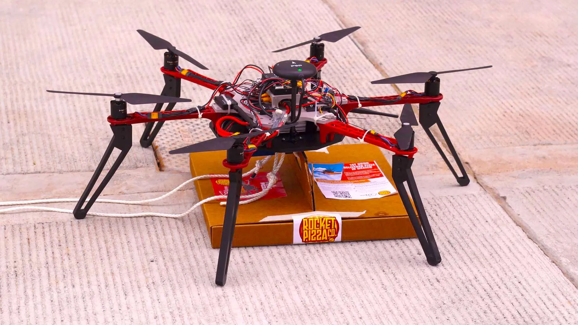 El dron Alexa sostiene una pizza.