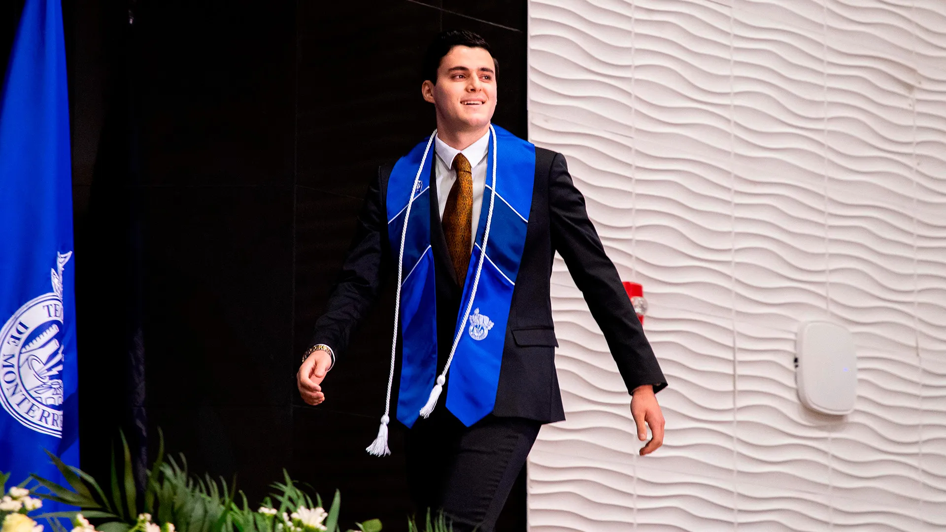 Alumno con estola del Tec de Monterrey avanza hacia la recepción de su título profesional en la graduación de la generación junio 2025