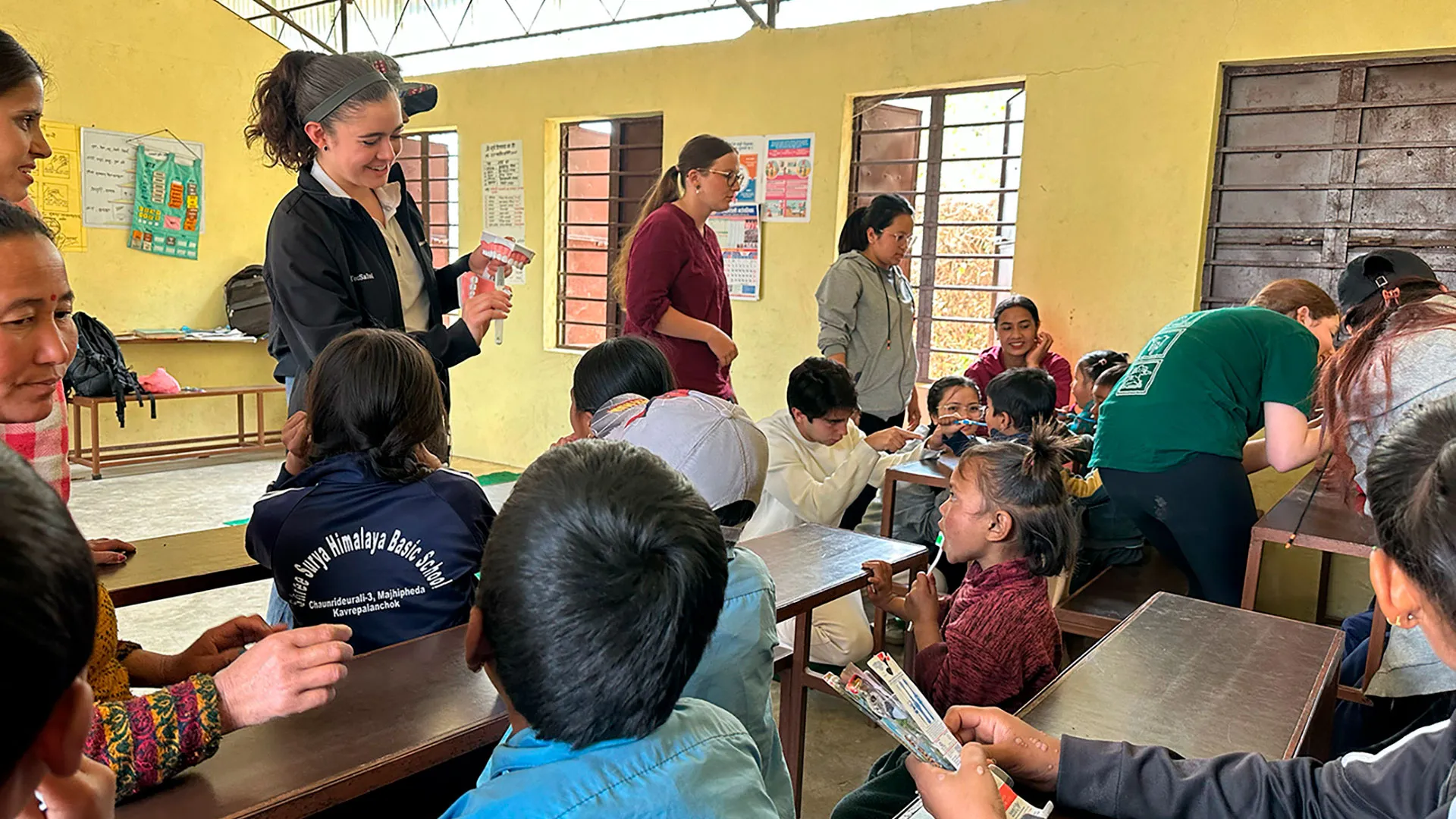alumnos sentados en escritorios viendo lección