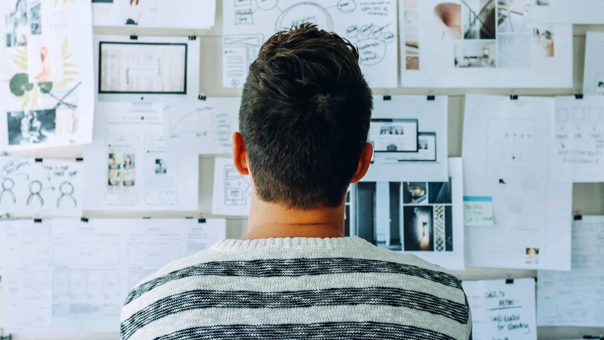 Joven ante un muro de diagramas y planeación