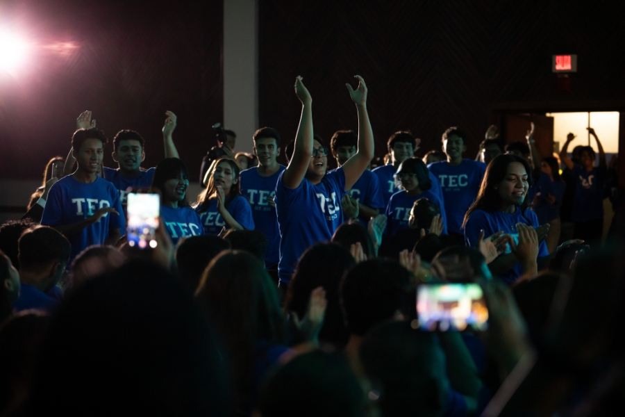 Estudiantes con playeras azules del Tec levantan las manos y celebran entre el p&uacute;blico durante la bienvenida de L&iacute;deres del Ma&ntilde;ana.