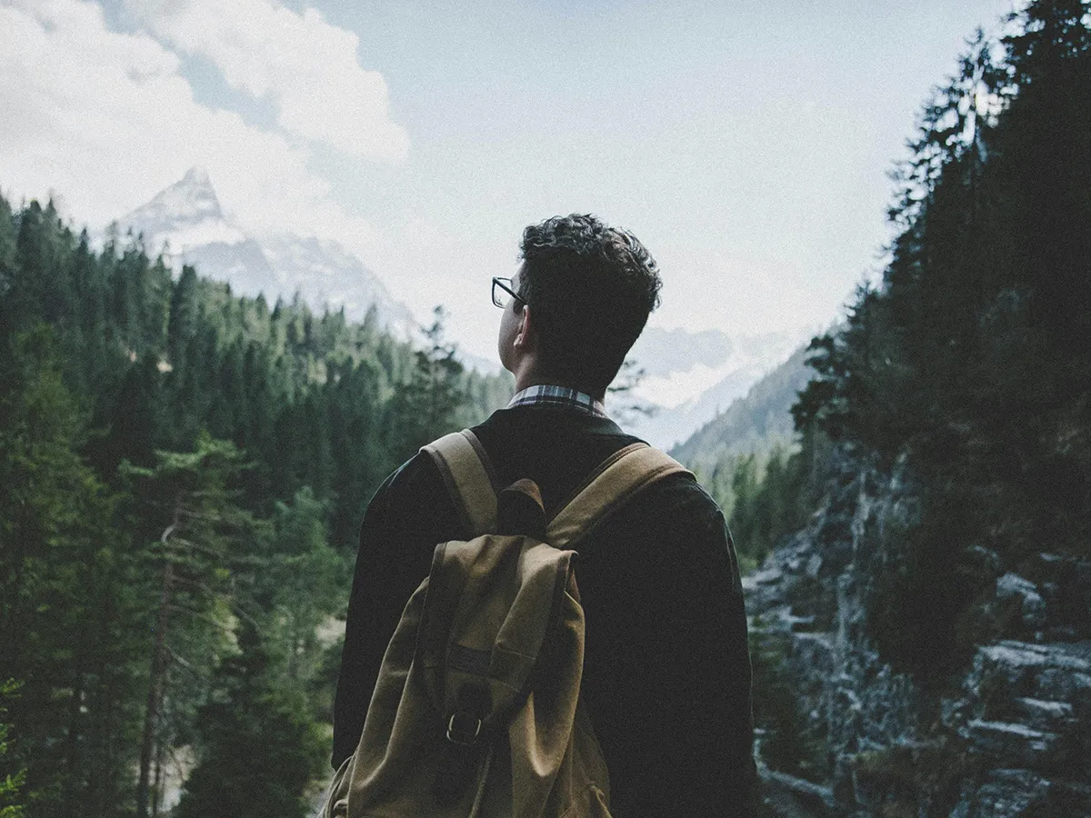 Viajero entre montañas observando el horizonte