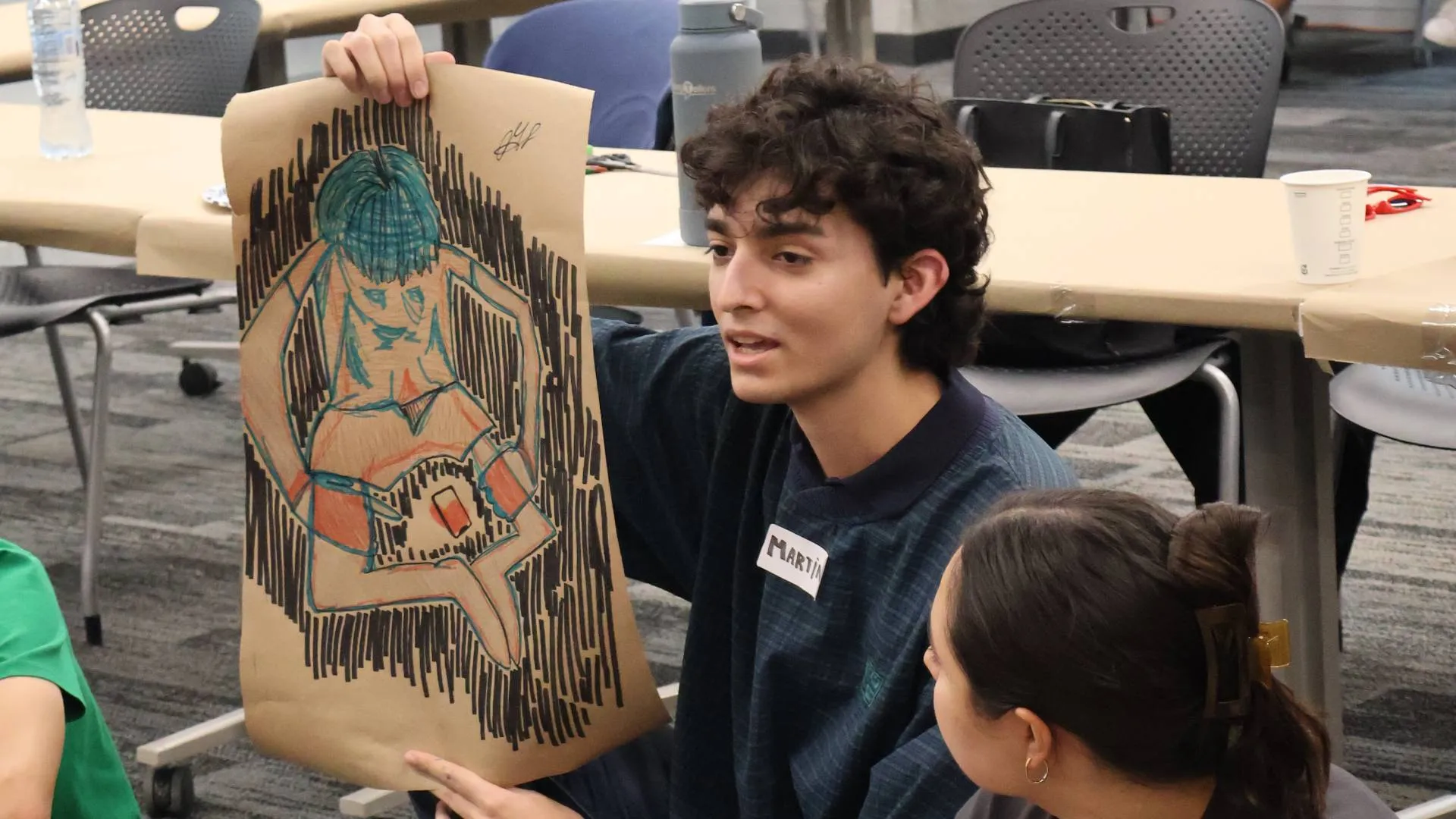 Becario de la primera generaci&oacute;n del curso mostrando un dibujo