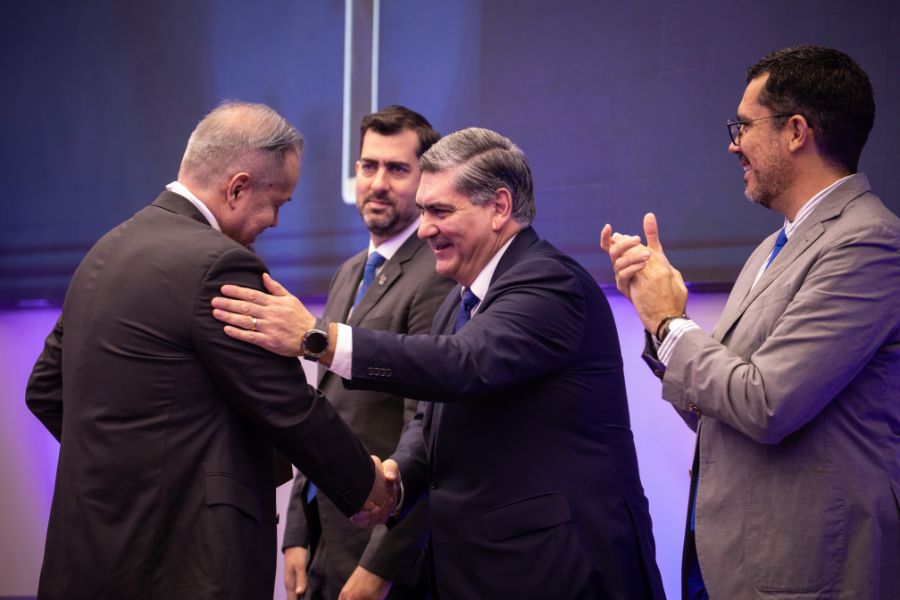 David Garza Salazar estrecha la mano de Francisco Javier Delgado Cepeda durante la entrega del Premio Profesor Inspirador 2026, mientras Juan Pablo Murra y Roberto &Iacute;&ntilde;iguez observan y aplauden sobre el escenario.