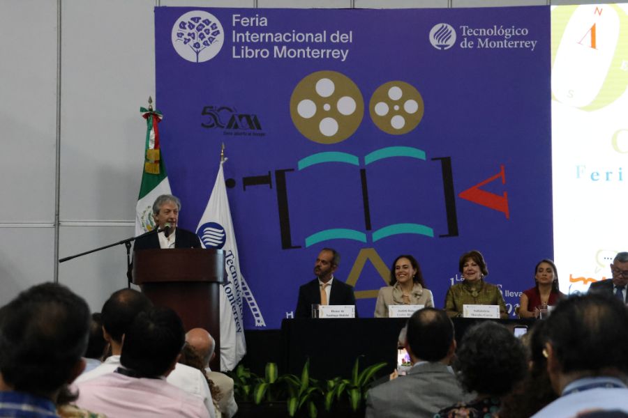 David Toscana ofrece una charla durante una edici&oacute;n anterior de la Feria Internacional del Libro de Monterrey. El escritor aparece en un podio frente al p&uacute;blico, acompa&ntilde;ado por integrantes del pres&iacute;dium y con el escenario de la FIL Monterrey al fondo.