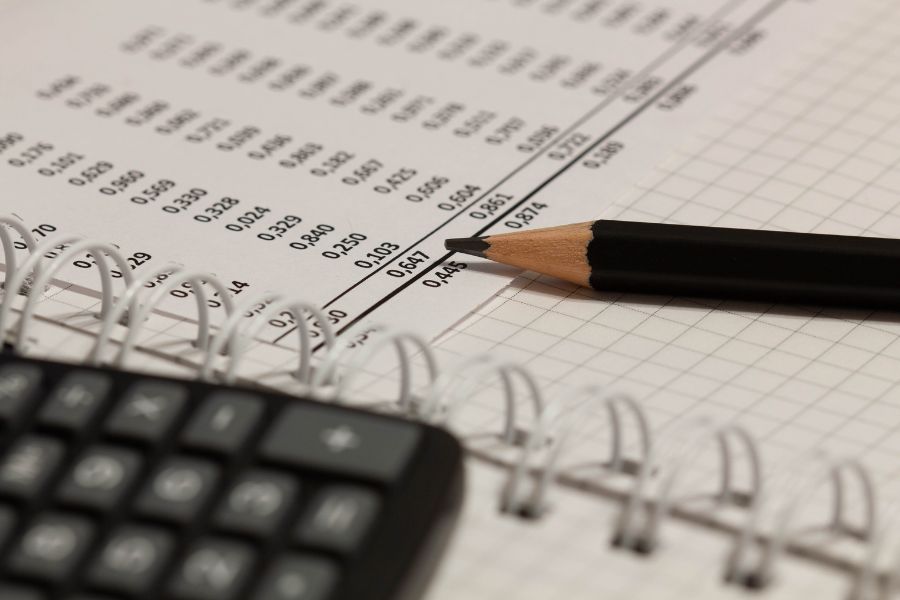 Informe financiero, l&aacute;piz y papel con n&uacute;meros sobre la mesa en la oficina. Una hoja de papel llena de datos comerciales. N&uacute;mero de cuentas en el documento de datos. Documentos comerciales en la mesa de oficina.