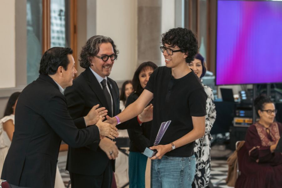 Estudiante recibe un reconocimiento de manos de organizadores durante la ceremonia del Concurso de Creación Literaria de VIBRART 2026.