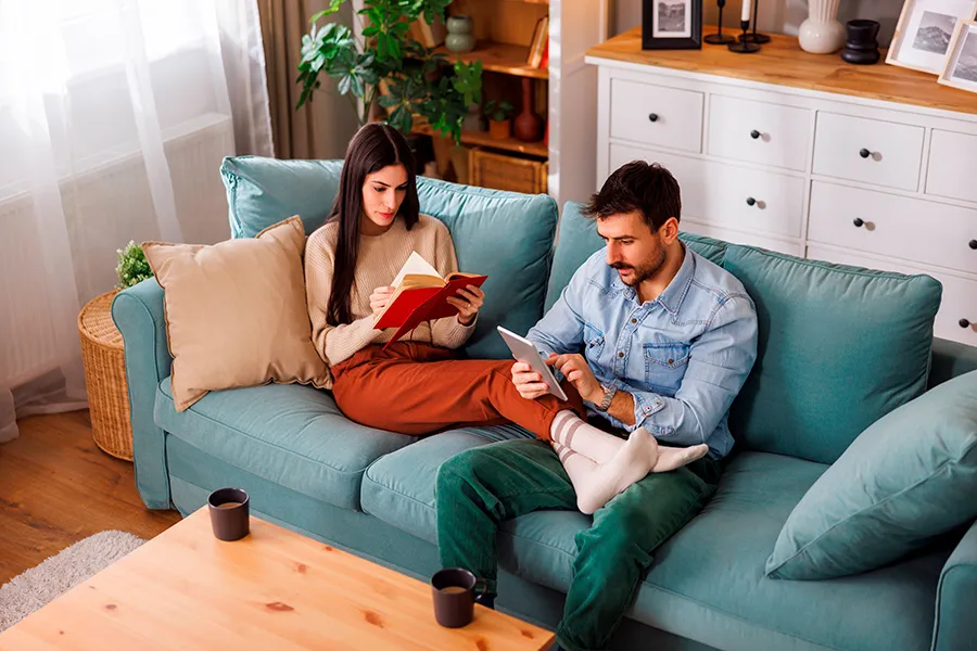 Pareja leyendo un libro y con una tableta electr&oacute;nica.
