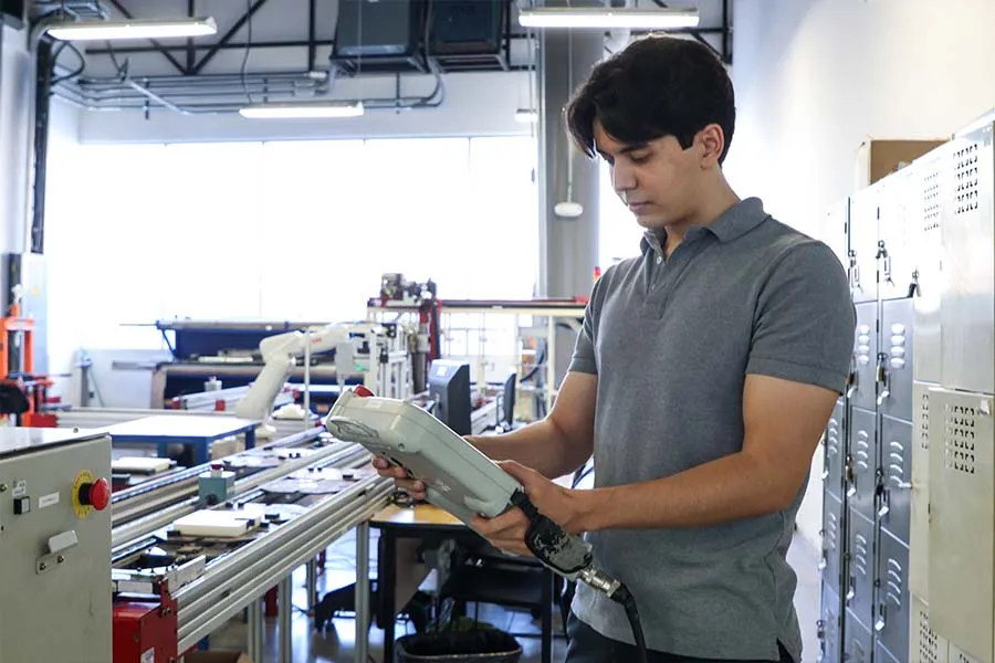 Estudiante maneja maquinaria en laboratorio.