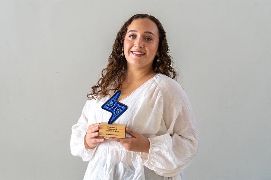 Olga Durón posando con su Premio a la Trayectoria Emprendedora.