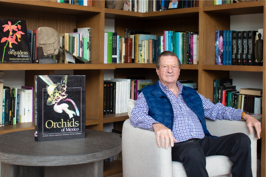 Eric Hágsater en su estudio junto a su libro sobre las orquídeas de México.