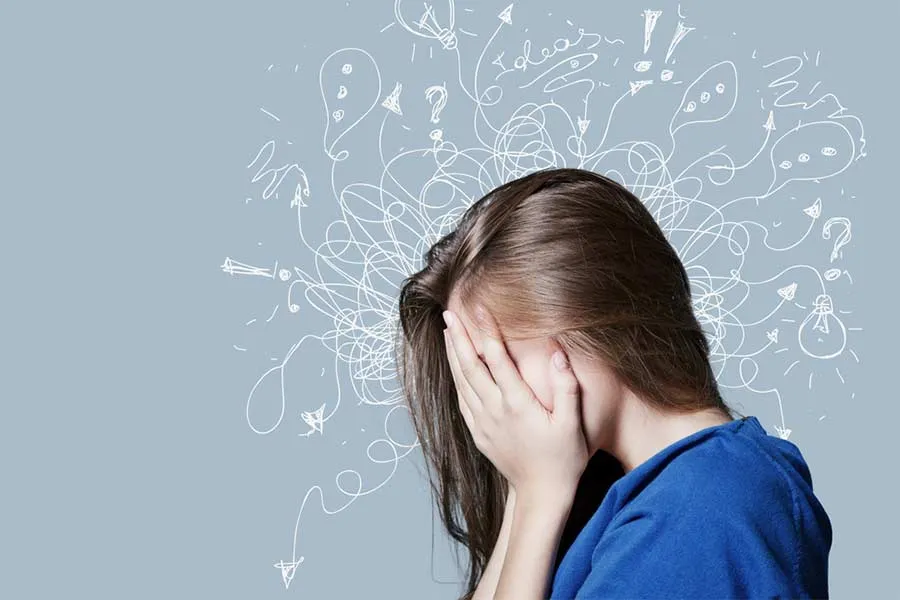 Joven tap&aacute;ndose la cara por ansiedad