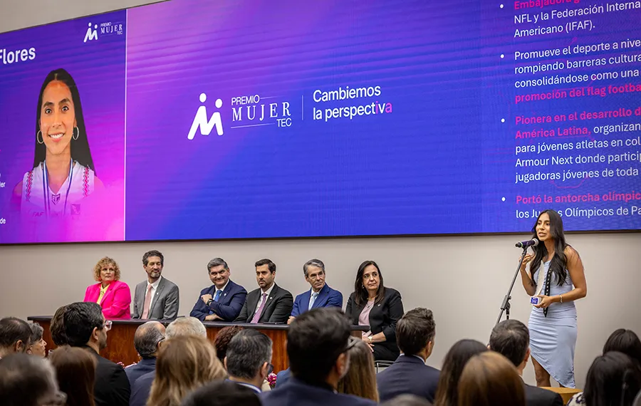 Pres&iacute;dium del Premio Mujer Tec 2026 mientras una ganadora habla a la audiencia.
