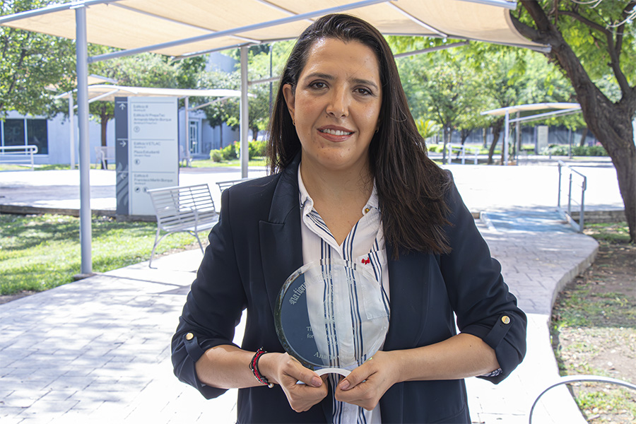 Profesora mexicana posa con su reconocimiento internacional por ganar un concurso de cuentos