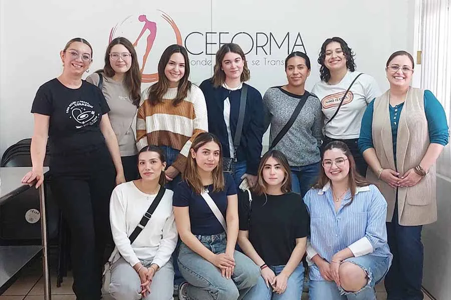 Un grupo de 11 mujeres posando juntas.