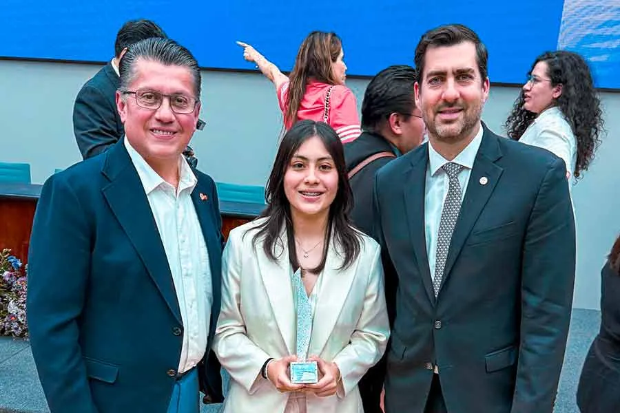 Sara Ramírez recibe Premio Mujer Tec por excelencia, posando junto a dos funcionarios en una ceremonia oficial.