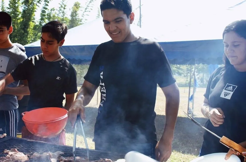 Sergio Sánchez asando carne junto con compañeros
