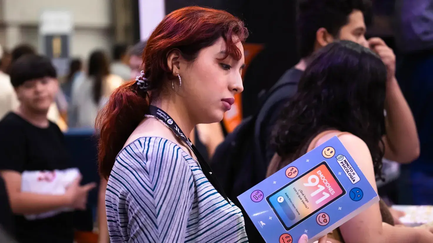Mujer joven sosteniendo un libro durante la Feria Internacional del Libro Monterrey