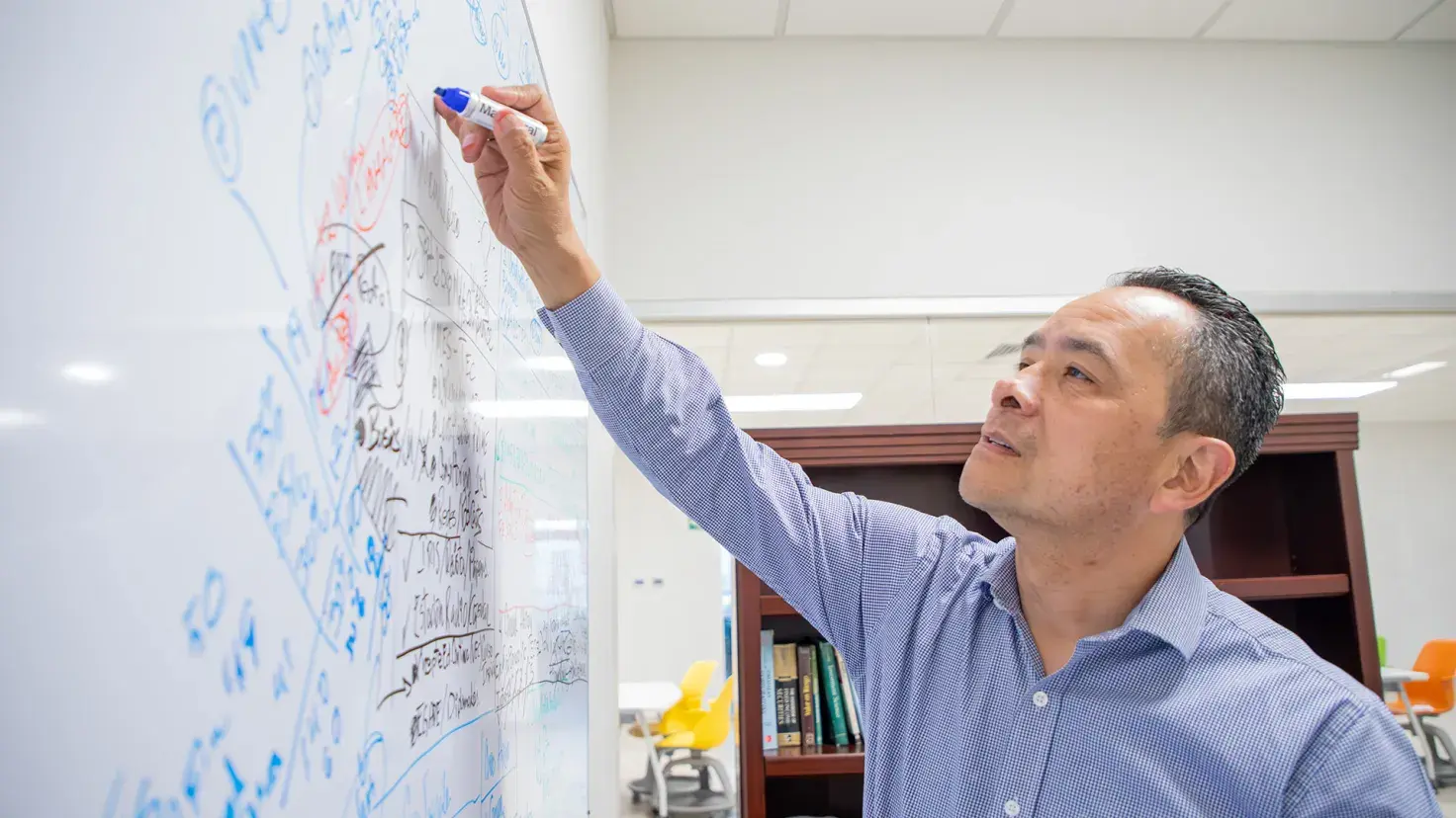 Profesor de la Escuela de Negocios del Tec de Monterrey campus Laguna utiliza pintarrón para hacer apuntes