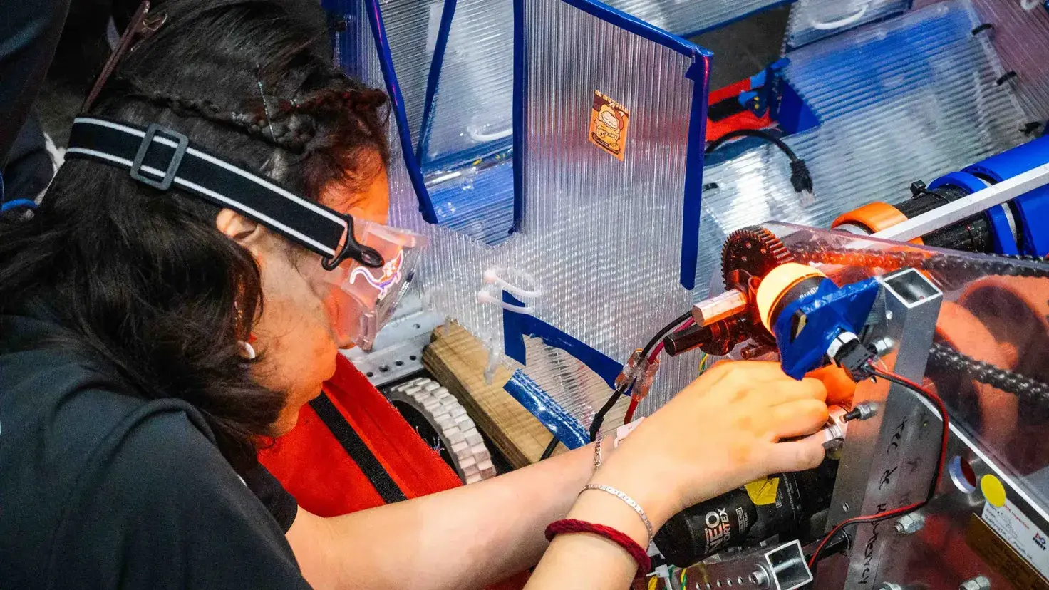 Estudiante de prepatec arreglando robot en FIRST