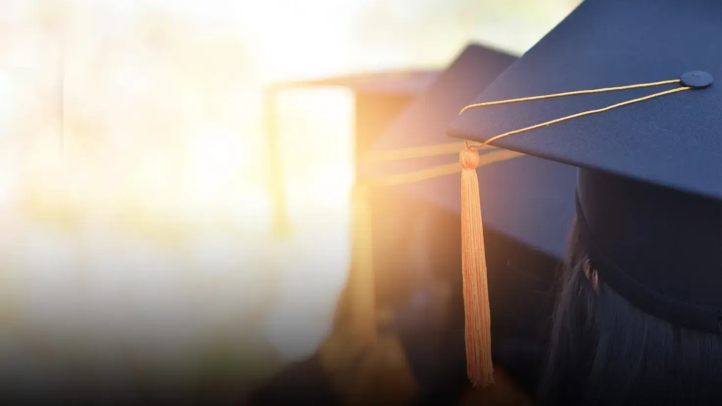 Vista de atrás de la cabeza de una joven graduada portando su gorra de graduación. 