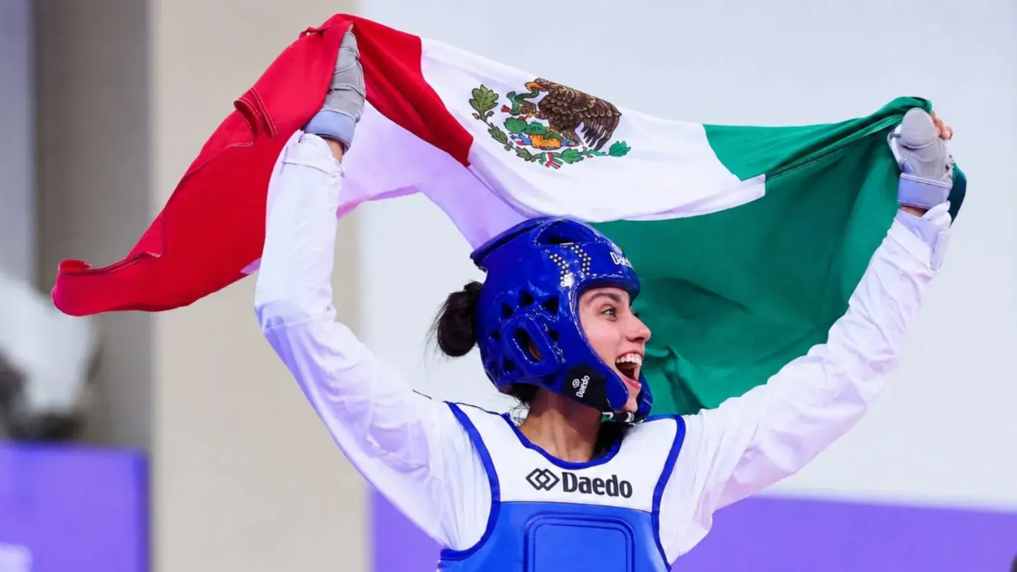 Atleta de taekwondo Nadia Ferreira celebrando con la bandera mexicana