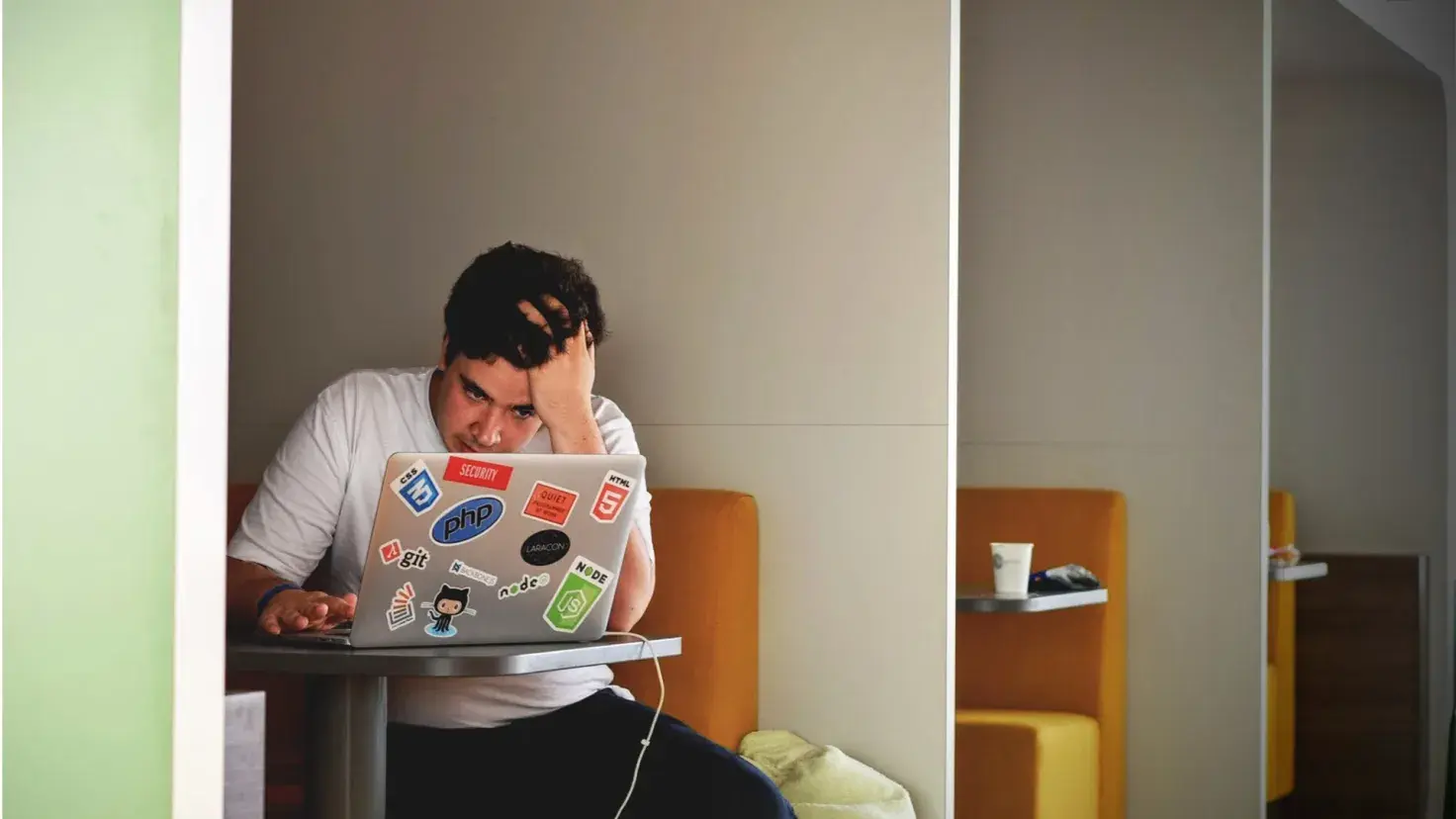 Estudiante frustrado por inicio de semestre frente a computadora