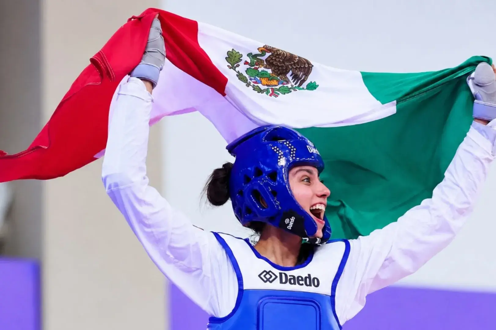 Atleta de taekwondo Nadia Ferreira celebrando con la bandera mexicana