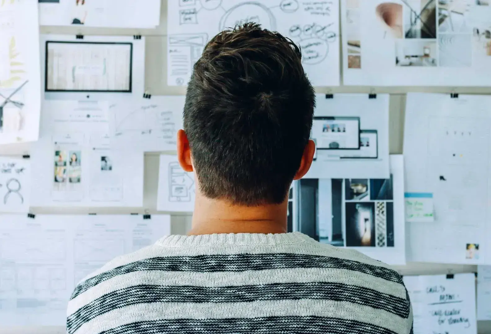 Joven ante un muro de diagramas y planeación