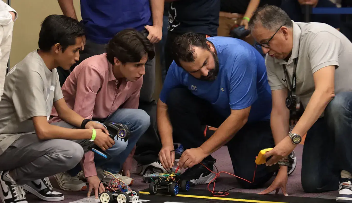 Estudiantes y profesores analizando un vehículo.