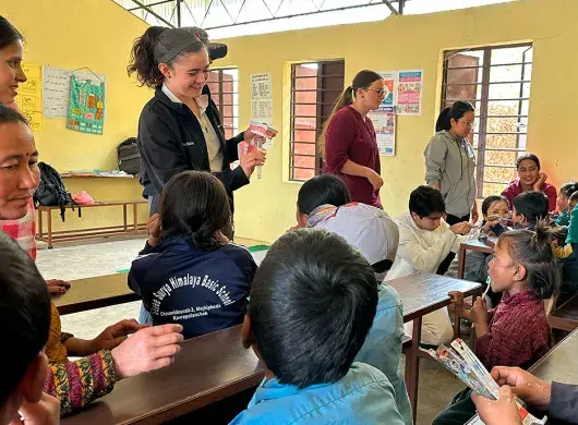 alumnos sentados en escritorios viendo lección