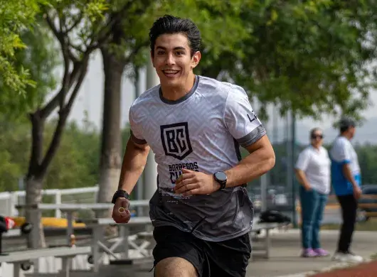 Alumno sonriente corriendo en atletismo