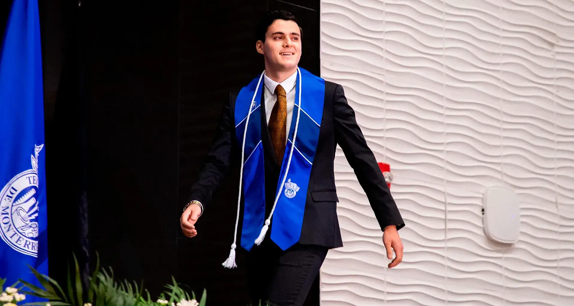 Alumno con estola del Tec de Monterrey avanza hacia la recepción de su título profesional en la graduación de la generación junio 2025