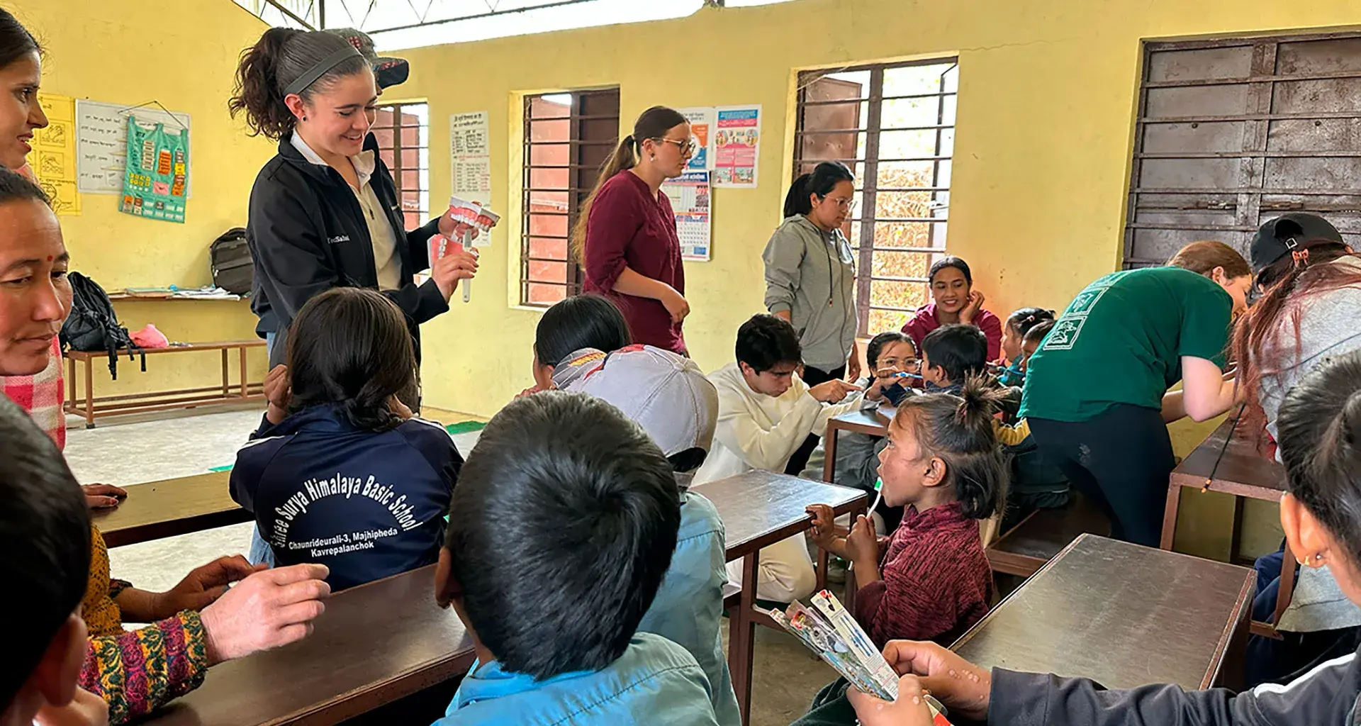 alumnos sentados en escritorios viendo lección