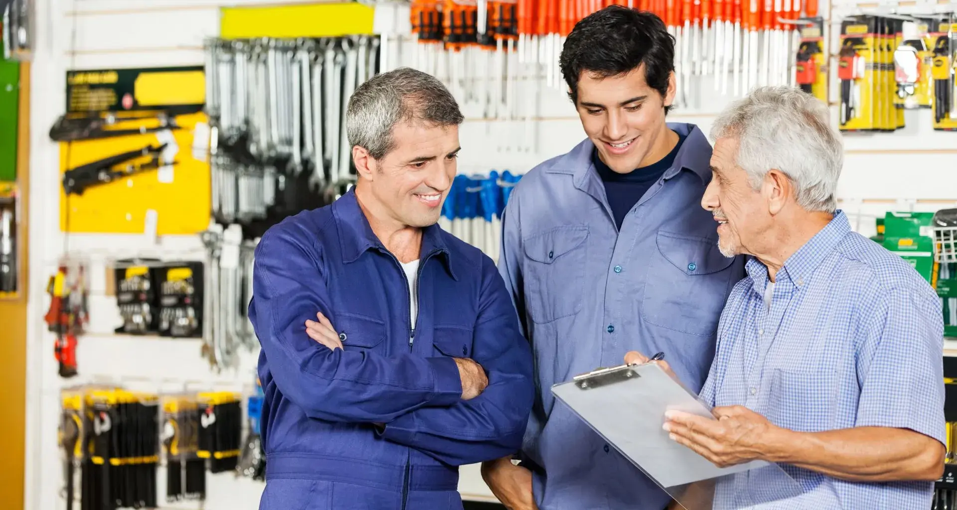 Tres generaciones de hombres platicando en una ferretería, concepto de una empresa familiar