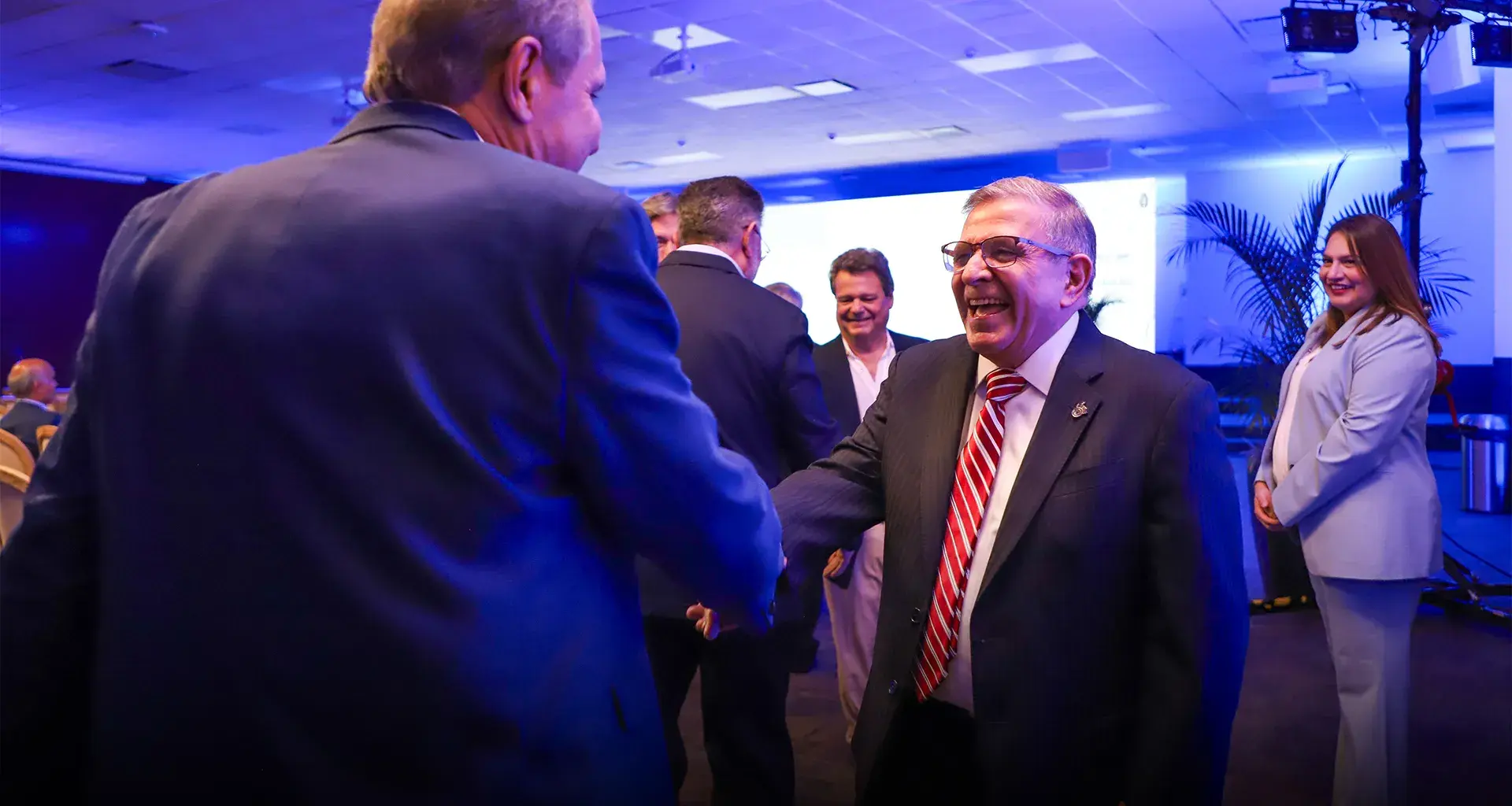 Dos hombres vestidos de traje dándose la mano.