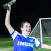 Jugadora de Borregos Laguna con uniforme azul y blanco festeja con el trofeo de primer lugar el campeonato femenil de fútbol soccer