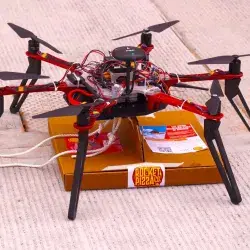 El dron Alexa sostiene una pizza.