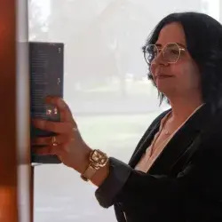 Directora de Mentoría de PrepaTec Laguna con vestimenta profesional toma libro de estante