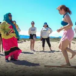 Adolescente hace baile tradicional guiada por un miembro de la comunidad Comca'ac en la playa.