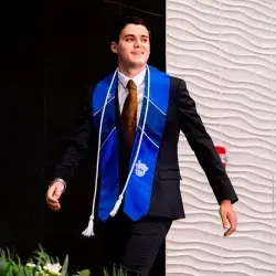 Alumno con estola del Tec de Monterrey avanza hacia la recepción de su título profesional en la graduación de la generación junio 2025