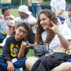 Participante y voluntaria sonriendo en campamento Vive Extremo