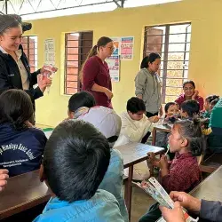 alumnos sentados en escritorios viendo lección
