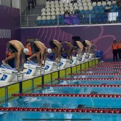 Competidores de natación preparandose para iniciar la carrera.