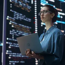 mujer con laptop viendo pantallas